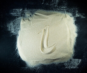 Greek letter iota written on the white sand with black background
