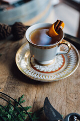 whiskey hot toddy cinnamon orange star anise in vintage teacup on wood bourbon barrel holiday happy...