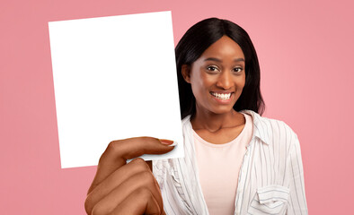 Pretty black woman showing empty card, pink studio background