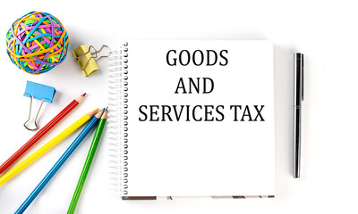 Notebook ,pencils,pen and rubber band with text GST GOODS AND SERVICES TAX on the white background