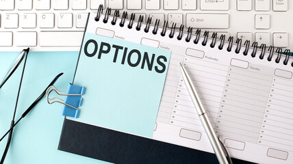 OPTIONS text on blue sticker on planning and keyboard,blue background