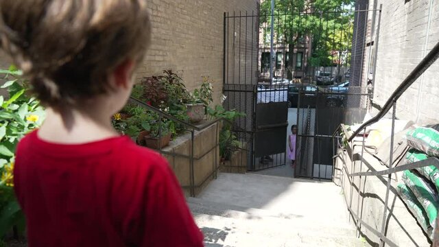 A little boy waits for his friend to come over to play on a summer day