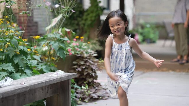 Little barefoot asian girl running frenetically in the courtyard