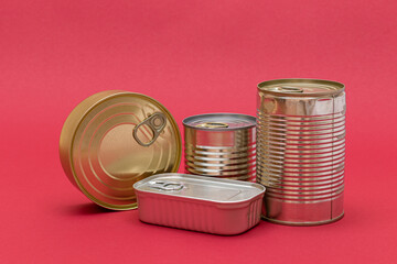 A Group of Stacked Tin Cans with Blank Edges on Red Background. Canned Food. Different Aluminum Cans for Safe and Long Term Storage of Food. Steel Sealed Food Storage Containers