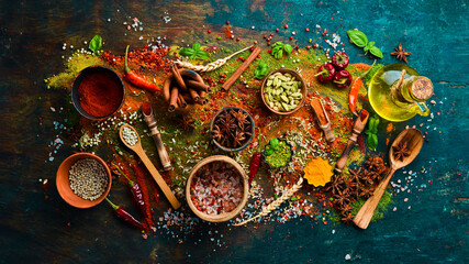 Set of spices and seasonings on a black stone background. Top view.