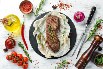 Beef Sirloin steak. Juicy cooked steak with rosemary and spices. Top view. Rustic style. Flat Lay.