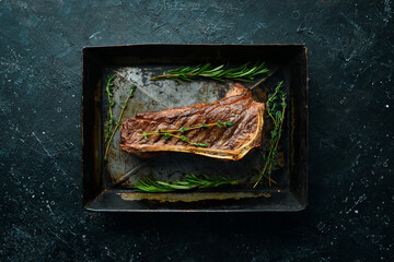 Grilled New York beef steak on the bone, herbs and spices. Juicy cooked steak. Top view. Rustic style. Flat Lay.