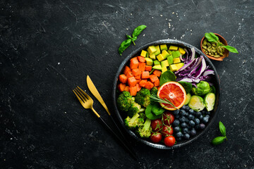 Vegan Buddha Bowl: Sweet Potatoes, Blueberries, Avocados, Cabbage and Orange. Dietary food. Top view. Free space for your text.