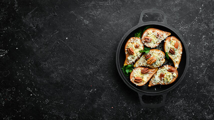 Baked pears with blue cheese and nuts. In a frying pan. Rustic style. Flat Lay.
