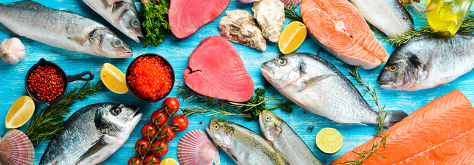 Fototapeta na wymiar Seafood background: salmon, tuna, caviar, oysters, dorado fish and shellfish on a blue wooden background. Top view. Seafood.