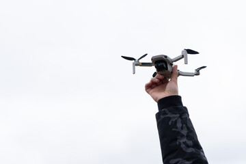Photo of a man's hand that launches a wireless drone into the sky. Quadrocopter concept