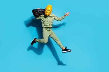 Fototapeta na wymiar Photo of crazy carefree guy jump carry radio vintage wear gorilla mask sportswear isolated blue color background