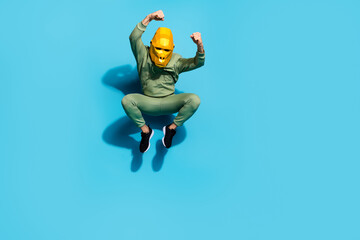 Fototapeta na wymiar Photo of weird spooky guy jump prepare air attack wear chimpanzee mask sportswear isolated blue color background
