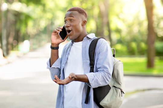 Surprised Black Guy Having Conversation On Mobile Phone At Park