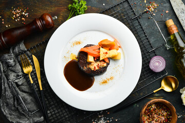 Veal steak baked with vegetables on a plate. Restaurant menu. European cuisine.