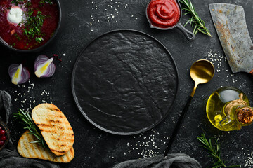 Black stone cooking background. Spices and vegetables. Top view. Free space for your text.