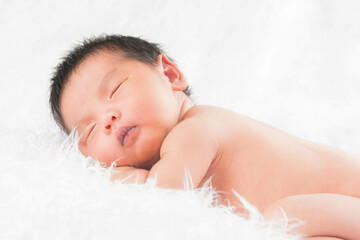 Newborn baby girl wearing angel wing.