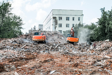 Excavators demolish the building. Dismantling of construction