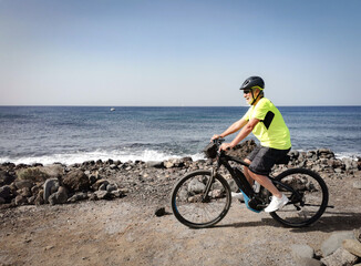 Fototapeta na wymiar Senior man outdoors biking at sea enjoying freedom and healthy lifestyle
