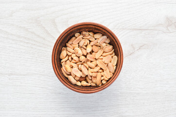 Peanuts in bowl on old table. Nut background. Top view.