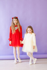 two girls in white and red dresses holding hands