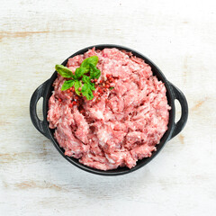 Minced pork in a bowl with spices. Top view. Rustic style.