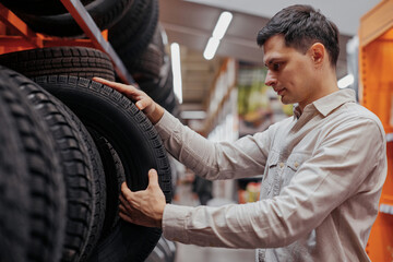 male customer choosing new tires in the supermarket .