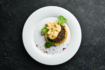 Beef steak with bulgur and mushrooms on a plate. Restaurant menu. European cuisine.