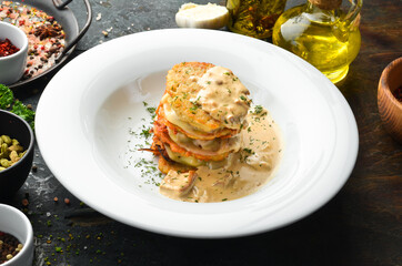 Potato pancakes with mushroom sauce. On a white plate. Restaurant menu. Top view.