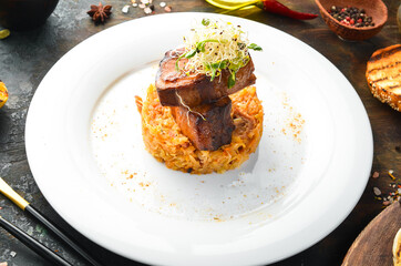 Juicy baked pork ribs with stewed cabbage on a plate. Top view.