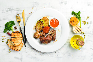 Lamb bone steak with vegetables on a plate. Top view.