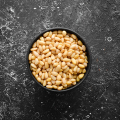 Pine nuts on a black stone background. Superfood. free space for your text. Top view.