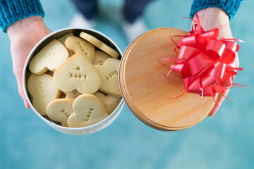 Cookie box. Heart-shaped cookies. Woman's hands. Valentine's day. Copy space
