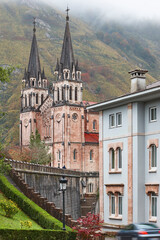 Fototapeta na wymiar Picturesque red stone basilica and mountains in Covadonga village. Asturias