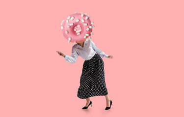 Contemporary art collage. Young girl in attire of 70s, 80s fashion style with glazed donut instead head dancing isolated on pink background