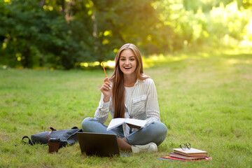 Idea Concept. Excited Student Girl Raising Pencil Up While Doing Homework Outdoors