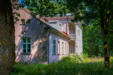Fototapeta na wymiar Old abandoned manor house of Koljala. Island Saaremaa, Estonia. Side view of manor house in sunny summer day.