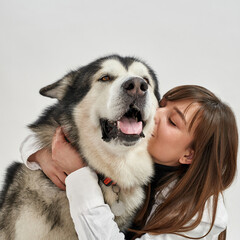 European girl hug Siberian Husky in white studio