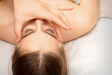 Fototapeta na wymiar Face massage with fingers of a masseur. Female facial skin care at a beauty spa salon