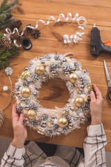 Woman making Christmas wreath on a wooden table. concept for New Year, Christmas