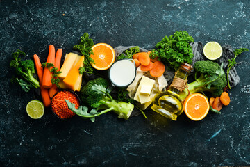 Set of vegetables, fruits and food on a black stone background. Foods are rich in vitamin A. Top view. Free space for your text.