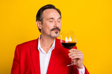 Portrait of handsome good mood peaceful man smell wine enjoying tasty aroma isolated on yellow color background - Powered by Adobe