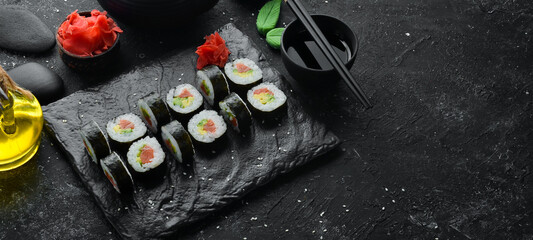 Sushi maki with salmon, avocado and nori. Free space for your text. Japanese Traditional Cuisine. Top view. Rustic style.