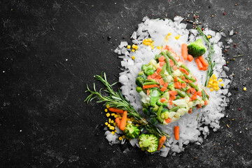 Assortment of frozen vegetables on ice. Stocks of food. Top view. Free space for your text.