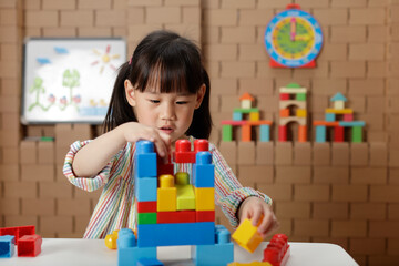 young irl playing creative toy blocks at home