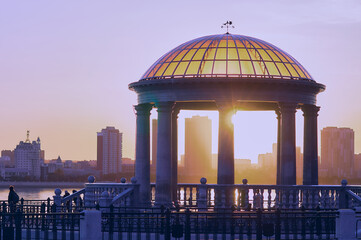 Rotunda with a balustrade on the banks of the Amur River in Blagoveshchensk on a summer evening.