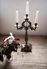 Dramatic floral decor with dark colours photographed on a wooden table.