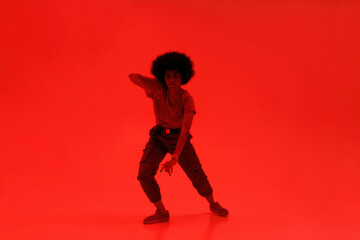 Fototapeta na wymiar Young black curly girl dancing hip hop dance