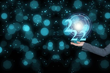 Businessman holding virtual 2022 number with bokeh background for merry Christmas and happy new year concept.