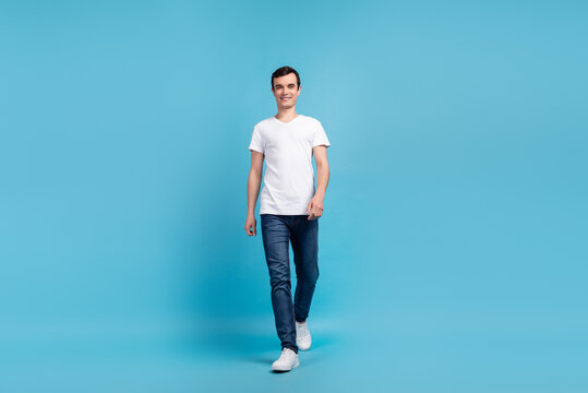Full body phoro of amazing attractive guy strolling down isolation blue color background